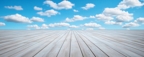 White wooden floor extending towards a stunning gradient of white clouds on a clear blue sky, creating a seamless and artistic infinite effect