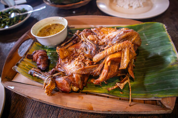 Indonesian javanese traditional food whole fried spicy chicken called Ingkung with broth