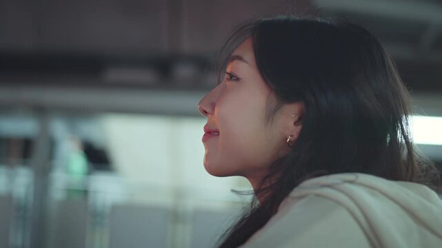 Close up - Attractive young asian woman opens his black eyes and smiling on a blurred background city night, Enjoy moment of peace, Happy young woman enjoys life