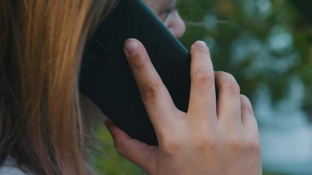 Unrecognizable woman head talking mobile phone calling on smartphone. Close up.