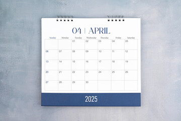 April 2025 desk calendar on gray cement wall background. Page of annual monthly calendar for plan.