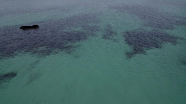 This aerial video captures the stunning beauty of Haukland Beach, located on the Lofoten Islands in Norway. The beach is known for its crystal-clear turquoise waters, pristine white sands, and dramati