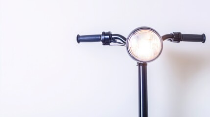 A close-up view of a bicycle handlebar featuring a round headlight, emphasizing its sleek design against a plain background.