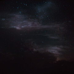 Fototapeta premium A dark night sky filled with stars and faint clouds, creating a sense of vastness and mystery.