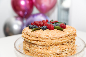 The homemade baked cake with berries and leaves for decoration.