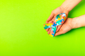 Autism ribbon. Autism awareness day. World autism awareness day with puzzle pattern ribbon on textured background. Colorful puzzle ribbon. Medicine concept. Space for text. Copy space