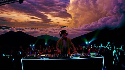 DJ performs at vibrant mountain festival with stunning sunset and crowd excitement