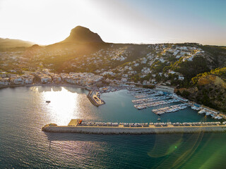 Costal city Xabia, at sunset. Known as Javea city, situated in Alicante province is a famous travel destination. Panoramic view of all region. Sunset colours with sun in the front of the camera.