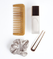 Hair care product, hair comb, scrunchy and hair pin on white background. Hair tools and accessories