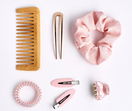 Hair brush and Collection of elastic band scrunchies and trandy hair clips on white background. Diy accessories and hairstyles concept