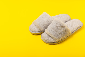 Soft slippers on a bright colored background, close-up. House slippers. Comfortable shoes for home. Foot care concept. Home comfort. Space for text. Copy space.