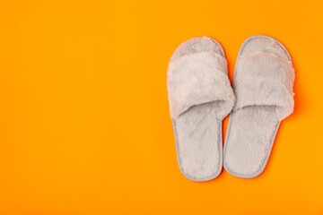 Soft slippers on a bright colored background, close-up. House slippers. Comfortable shoes for home. Foot care concept. Home comfort. Space for text. Copy space.