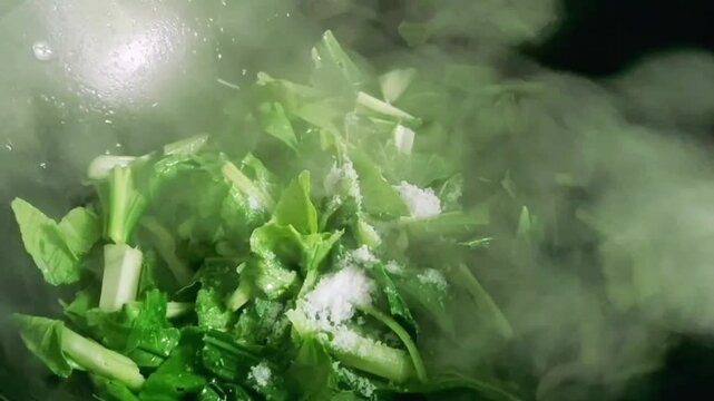 Women put and mix the salt with vegetables in the kichen