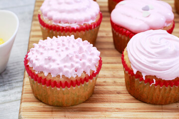 Pink muffins decorated with colorful sprinkles.