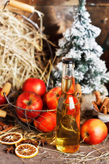Homemade cider in glass bottle on a country table decorated for Christmas.