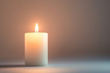 white pillar candle with a glowing flame on a soft gradient background