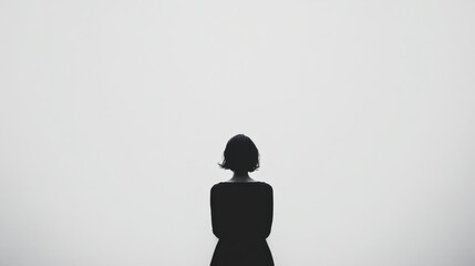 A woman is standing in front of a white wall