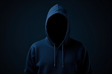 Anonymous figure in a dark hoodie against a dark background.
