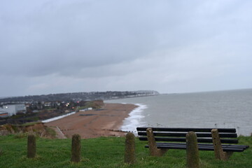 wooden bench looking out towards coastal Bexhill-On-Sea and Hastings 