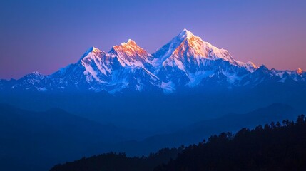 Majestic snow-capped mountain range at sunrise, bathed in warm golden light against a deep blue sky.