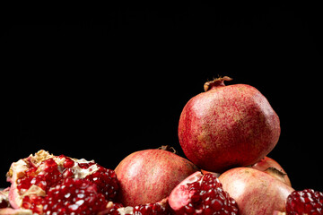 Ripe pomegranates, peeled and whole, place for text