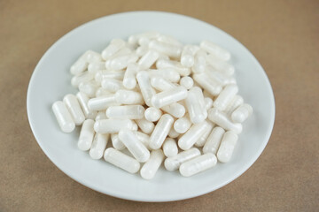 Female hand holding a spoon with white vitamins