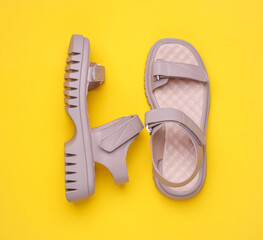 Women's leather sandals on yellow background. Summer shoes. Top view
