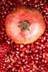 A whole pomegranate and pomegranate grains close-up.