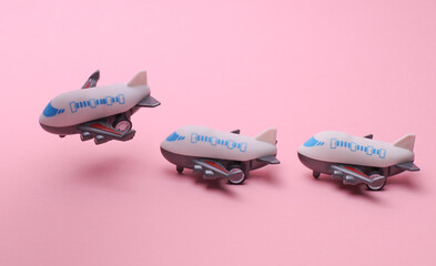 Toy airplanes flying on pink background