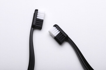 Black plastic toothbrushes on white background