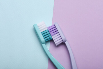 Plastic toothbrushes on pastel background. Top view