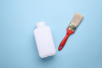 Can of primer with brush on blue background