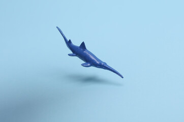Toy plastic shark swimming on blue background