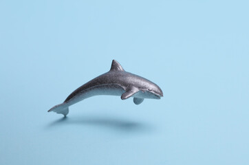 Toy plastic shark swimming on blue background
