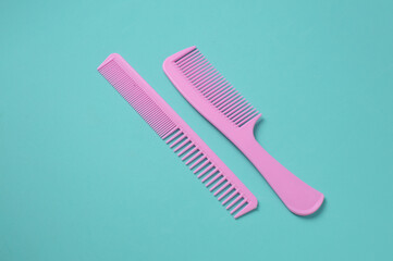 Set of pink plastic combs on mint green background.