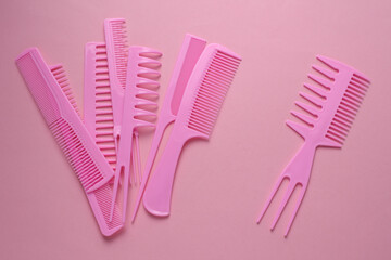 Set of plastic combs on pink background.