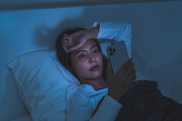 Mobile addiction and insomnia concept, asian young woman using smartphone before sleeping browsing...