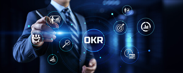 OKR Objectives key results. Businessman pressing button on screen.