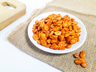 Balado peeled peas served on a white plate on a burlap cloth, isolated on a white background. Perfect for a snack.