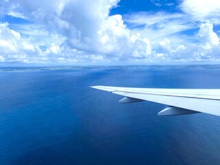 Obraz premium Soaring Over Chiba, Japan - Stunning Aerial Views of the Blue Sea, White Clouds, and Land from the Plane Window
