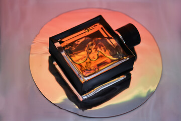 A bottle of perfume in the rays of the sunset.