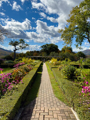 Brick Pathway in Flower Garden on a Clear Day