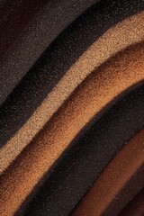 Elegant composition of textured sand patterns in shades of brown and black created by nature at the...