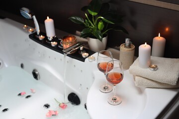Bathtub with glasses of wine and candles indoors. Romantic atmosphere