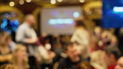 Footage featuring a blurred background of a busy event showcasing engaged and interacting guests throughout the scene