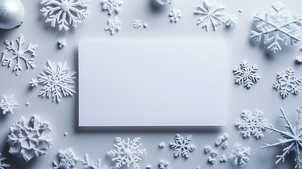 Winter Wonderland Mockup with Snowflakes. A visually appealing, flat lay design featuring various white snowflakes arranged around a blank white rectangle.