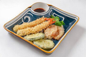 mixed tempura plate with fried shrimp and vegetables isolated on white background 