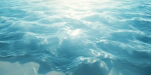 Naklejka premium Sunlit Aqua Ocean Waves Gently Rolling On Sandy Shore