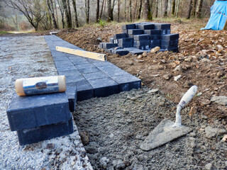 Pavoirs being laid at the side of a new concrete drive in the countryside
