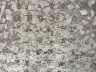 Close up of random textured dotted grey silver metallic fabric. Suitable for upholstery and other...